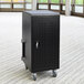 A black metal Luxor tablet charging cabinet on wheels.