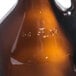 A close-up of a brown Libbey Amber Growler with a white logo.