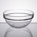 An Arcoroc clear glass ingredient bowl on a white surface.