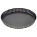 A round metal Wilton quiche pan with a scalloped edge and a removable bottom.