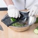 A person using a Mercer Culinary julienne hand slicer to cut cucumbers on a counter.