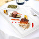 A Tuxton white rectangular china platter with food on a table.