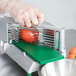 A person using a Garde tomato slicer to slice a tomato.