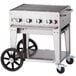 A Crown Verity liquid propane outdoor grill on a cart with wheels.