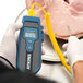 A person using a Cooper-Atkins EconoTemp Plus thermocouple thermometer to check the temperature of a pig.