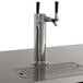 An Avantco double tap kegerator with stainless steel beer taps on a counter.