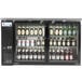 An Avantco black narrow glass door back bar refrigerator with beer bottles inside.