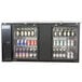 An Avantco black back bar refrigerator with bottles of beer and cans inside.
