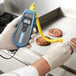 A person using a Cooper-Atkins EconoTemp thermocouple thermometer to check the temperature of a burger.