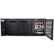 An Avantco black counter height back bar refrigerator with two solid doors open and bottles of beer inside.