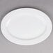A Tuxton bright white china oval platter on a gray surface.