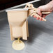 A hand using Vollrath batter boss to pour batter.