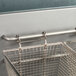 A metal basket with two handles in a Globe GFF50PG gas fryer.