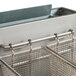 A stainless steel Globe liquid propane floor fryer with two baskets inside.