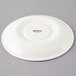 A white porcelain saucer with a white rim.