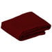 A folded burgundy Intedge cloth table cover.