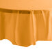 A table covered with a Creative Converting Pumpkin Spice Orange plastic table cover.
