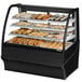 A True curved glass black dry bakery display case with various types of pastries.