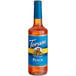 A Torani Sugar-Free Peach Syrup 750 mL glass bottle with a blue label.