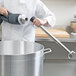 A person using an AvaMix blending shaft in a professional kitchen.