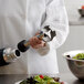 A person in a white coat using an AvaMix heavy-duty blending shaft to blend a salad.