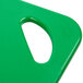 A close-up of a green Rubbermaid plastic cutting board with a handle.