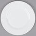 A white Arcoroc Zenix Intensity salad plate with a white rim on a gray surface.