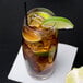 A Reserve by Libbey highball glass filled with ice tea and a lime wedge with a straw.