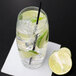 A Reserve by Libbey Symmetry cooler glass filled with water and lime slices with a straw.