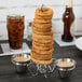 A Clipper Mill stainless steel rocket surfboard onion ring tower with sauce in the attached ramekins.