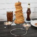 A Clipper Mill stainless steel onion ring tower with two ramekin holders filled with onion rings on a stand.