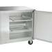A stainless steel Traulsen undercounter freezer with left and right hinged doors open.