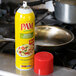 A yellow can of PAM Olive Oil Release Spray next to a pan.