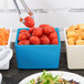 A blue square container with tomatoes in it.