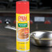 A can of PAM Canola Release Spray on a counter next to a stack of pancakes.
