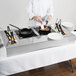 A chef preparing food on a Tablecraft countertop induction station.