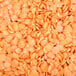 A pile of dried red lentils on a white background.