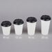 A row of white Choice paper cups with black travel lids.