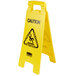 A yellow Rubbermaid caution wet floor sign with black text and a black and white warning sign.