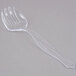 A clear plastic serving fork with a handle.