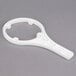 A white plastic C Pure filter wrench with a circular design and a handle.