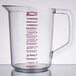 A Rubbermaid clear polycarbonate measuring cup with red and blue lines and writing on the handle.