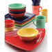 A stack of Tuxton Concentrix colorful bowls on a table.