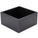 A black Cal-Mil cube riser on a table.