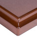 A brown plastic lid with a square brown surface.