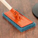 A 3M blue scrubbing pad on a wood table.
