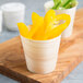A Tablecraft small wooden disposable serving cup filled with yellow bell peppers.