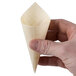 A hand holding a Tablecraft mini wooden serving cone.