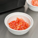 A bowl of diced tomatoes and a bowl of chopped onions on a counter.