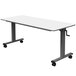 A white rectangular Luxor nesting table with black wheels.